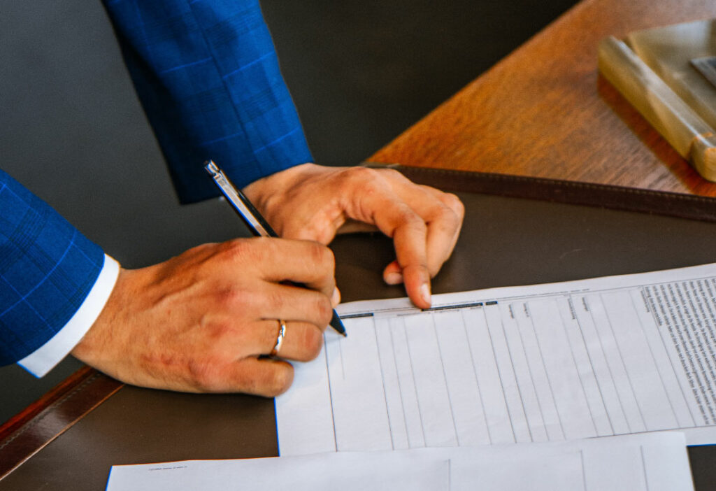 manos hombre firmando documentos