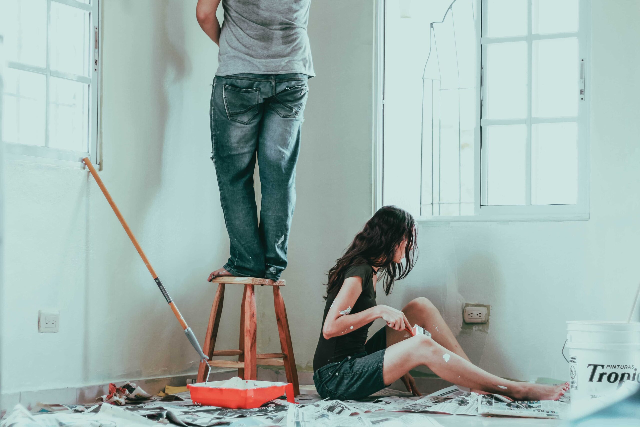 hombre y mujer pintando casa